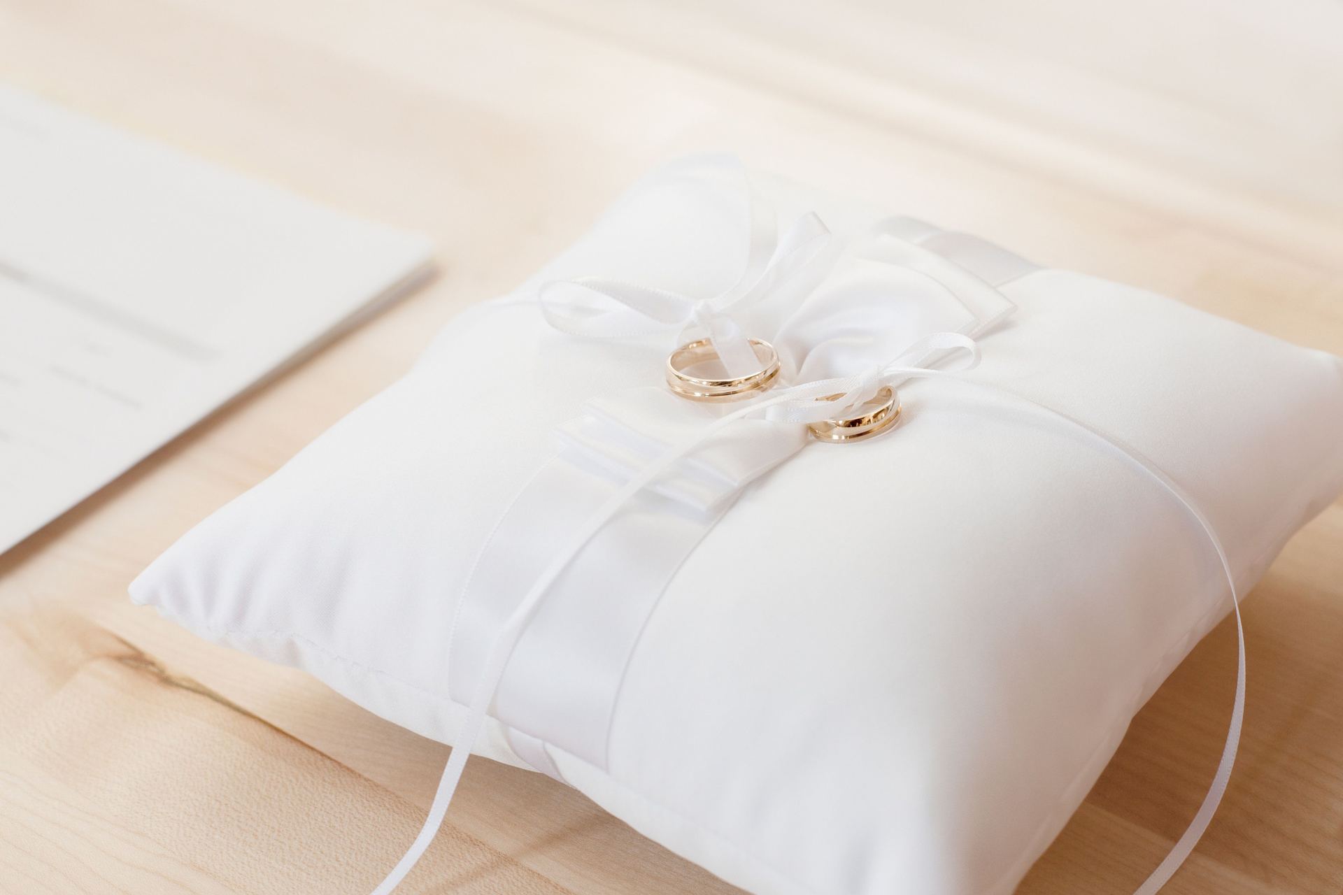 Wedding rings resting on a white ring pillow